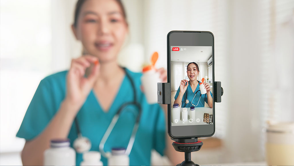 Mutélios influenceurs santé entre mensonges et profits, femme se filmant en live en présentant des médicaments