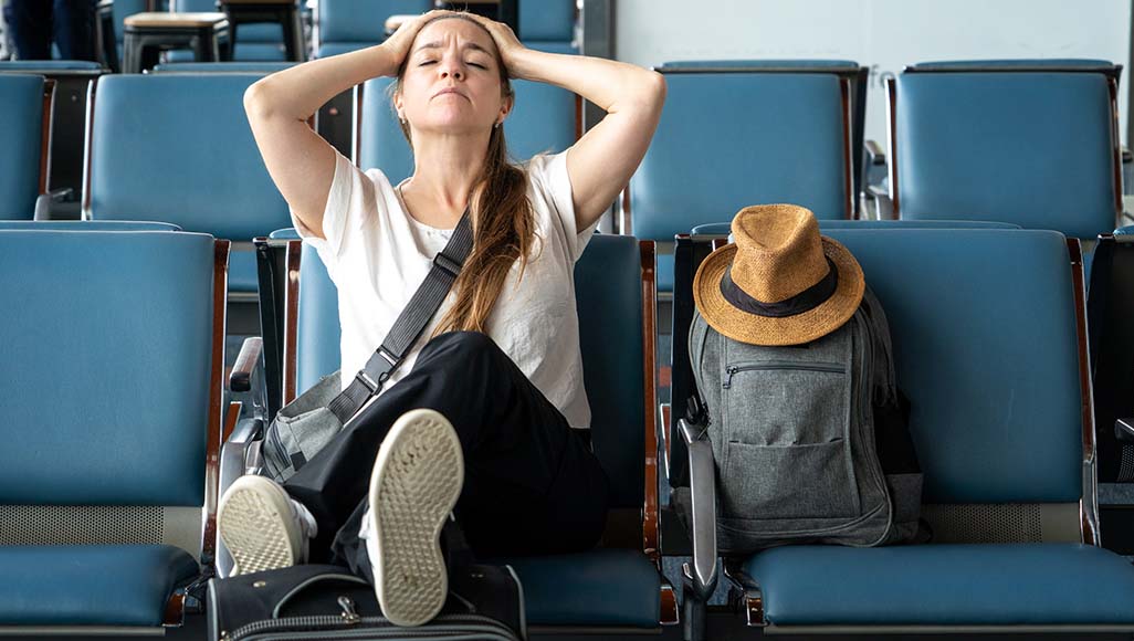 Mutélios décryptage, retour de congés difficile, femme anxieuse assise sur un siège à l'aéroport