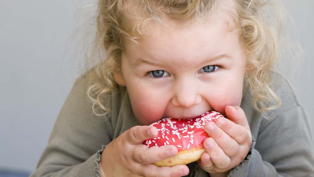 Mutélios Le Mag #4 - Nutrition, pourquoi de vient-on accro au sucre, petite fille mangeant un beignet