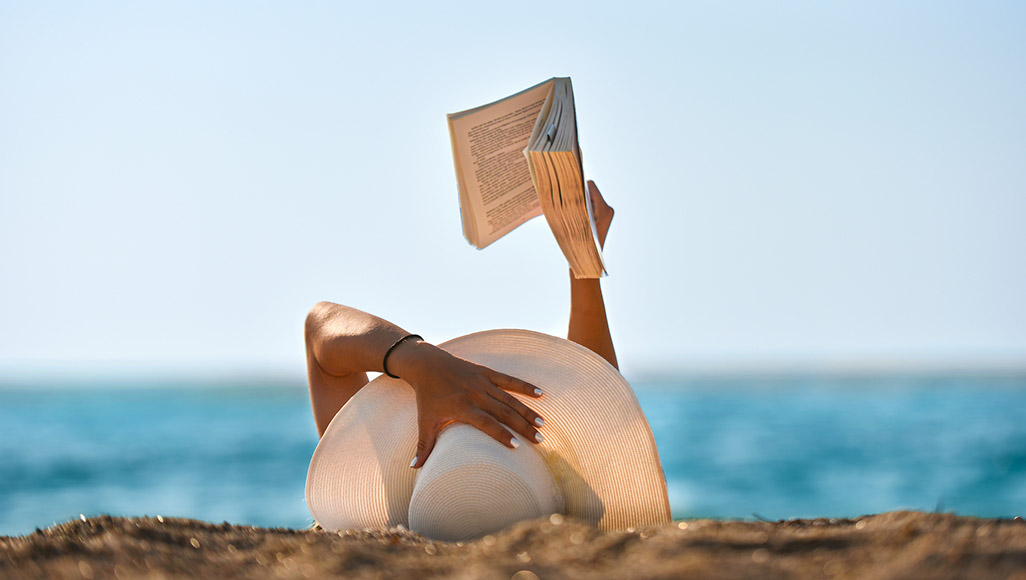 Mutélios décryptage vacances, femme allongée à la plage avec un livre