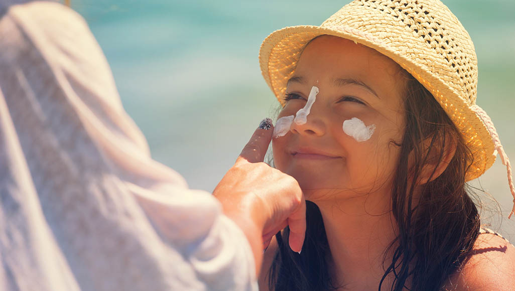 Mutélios le plus mutélios produits solaires, jeune fille se mettant de la crème solaire