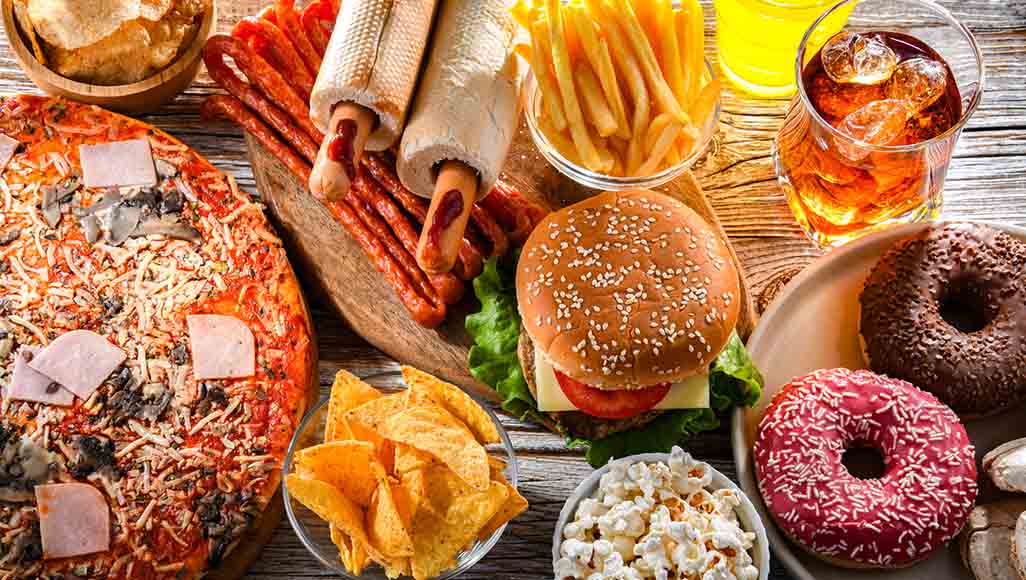 Mutélios Le Mag Online N°4 - Nutrition, assiette d'aliments ultra transformés (donughts, hamburgers, pizza)