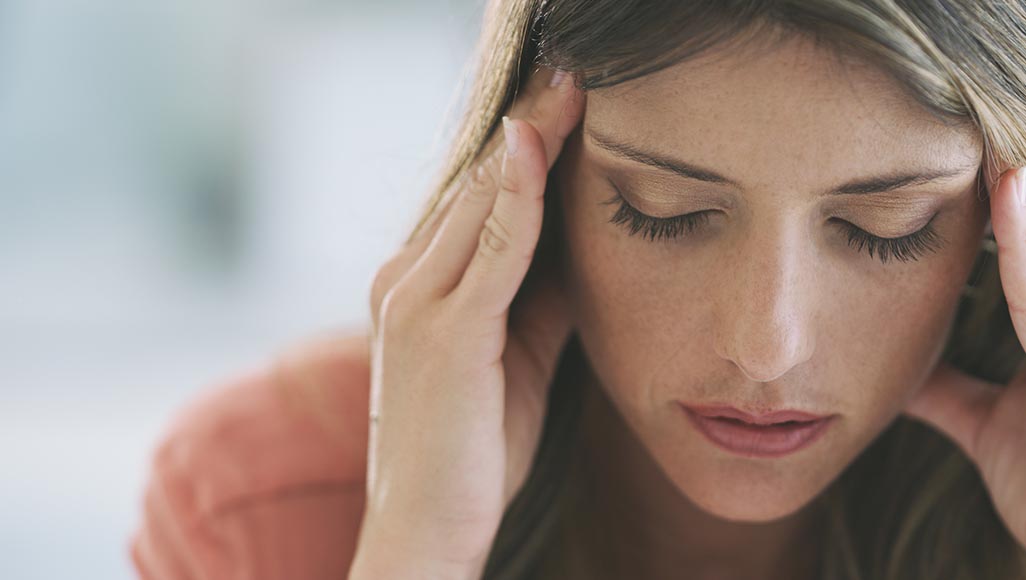 Mutélios Migraine Femme se tenant les tempes à cause d'une migraine