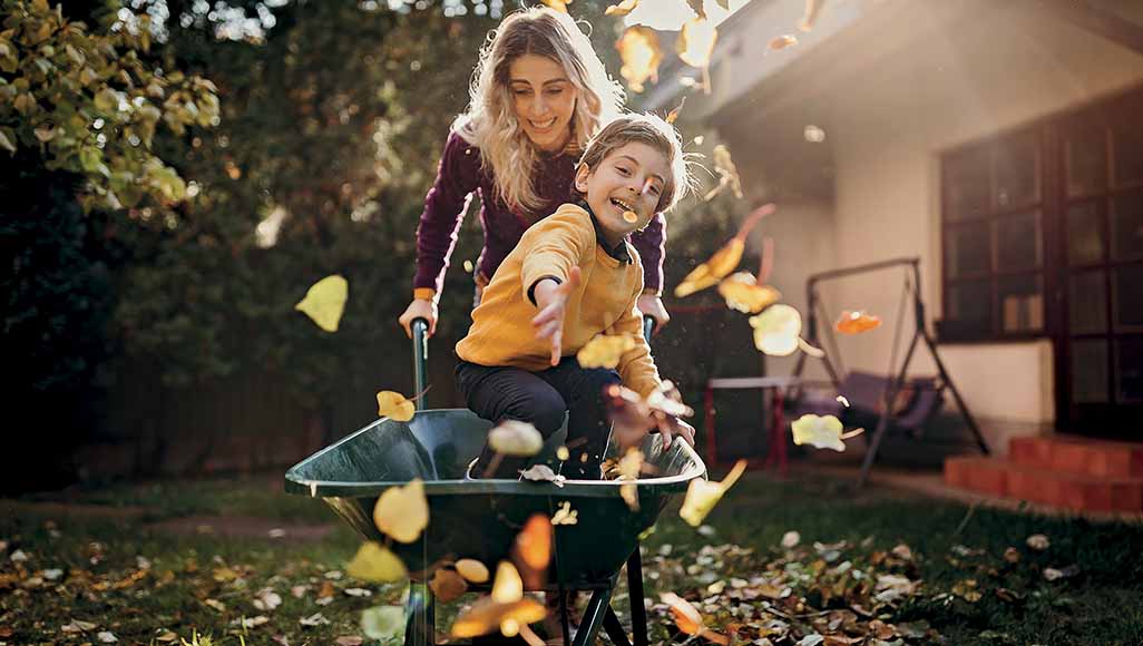 Mutélios apprécier automne femme et enfant jouant dans les feuilles