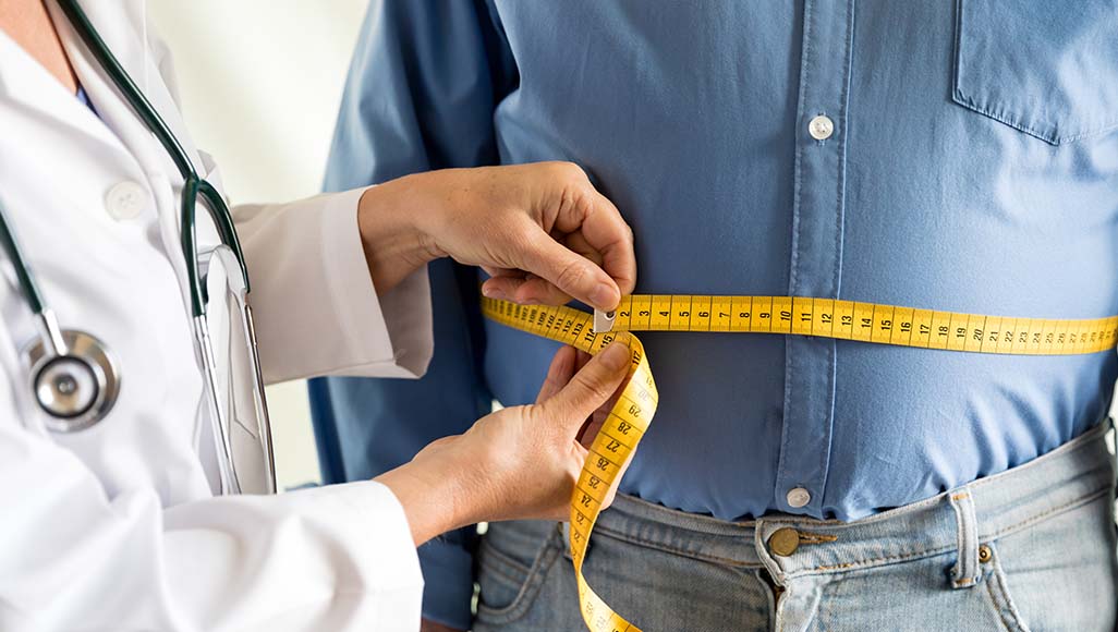 Mutélios risques obésité, médecin vérifiant le poids d'un patient
