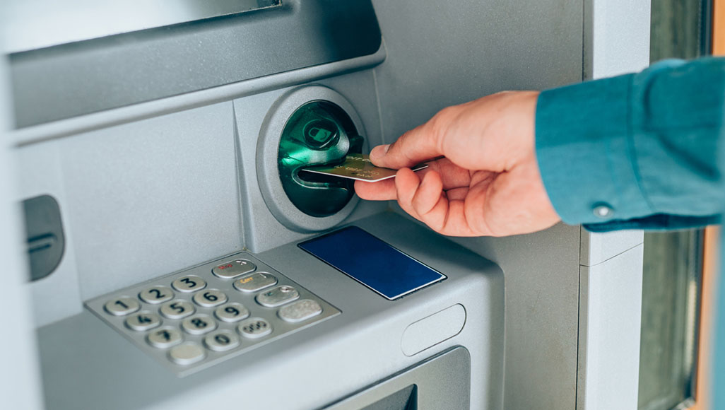 Mutélios alerte au shimming, personne insérant une carte bancaire dans un distributeur