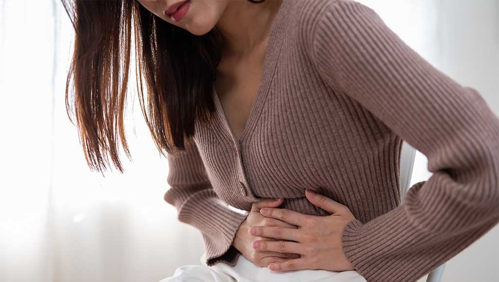 Mutélios Vomir Femme se tenant le ventre